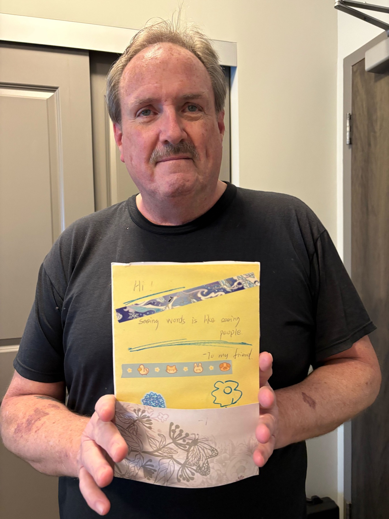 A veteran holding a student letter of appreciation